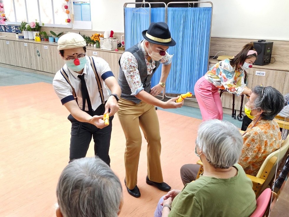 小丑醫生「豆腐」（左起）和「蜻蜓」（葉威志，火哥）、「呱呱」（鄭錡雯）與北榮日照中心的長者們同樂。（臺北榮民總醫院遊詣居日間照顧中心提供）