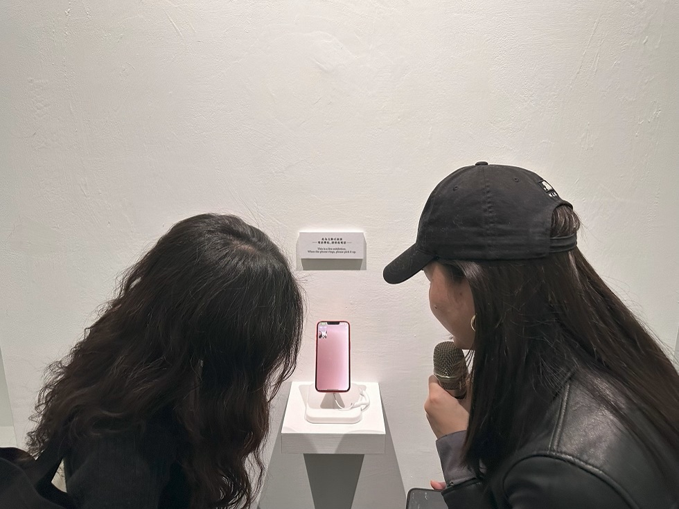 擱在展場樓梯間的手機突然傳來Line訊息，讓觀眾被迫展開一場與「媽媽」的對話。明日和合製作所《母親凝視過你》。（攝影／王欣翮）