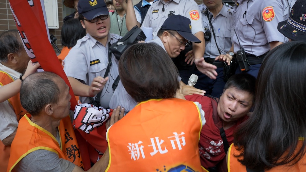 2017年9月20日,泰山說明會現場發生衝突,身穿紅衣的俊奇遭警方壓制。