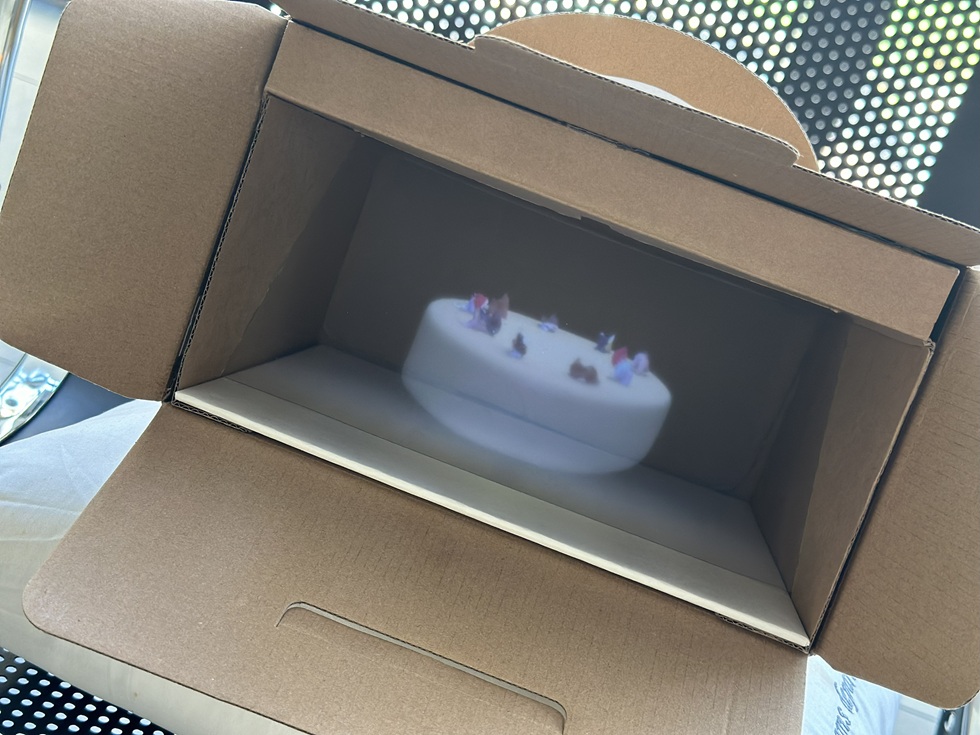 張庭甄「祝福是不幸的尾巴」系列（2025）將影片投放在蛋糕盒中。（攝影／王欣翮）