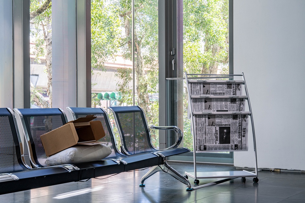 展場中，機場常見的休息座椅上，有個可疑紙盒吸引觀眾靠近。（北師美術館提供，攝影／dulub studio）