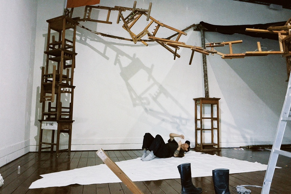 佈展期間marang aly(李杰)以身體的重量壓在紙張的黏合處,使接縫更加緊密牢固,身體的動作也成為作品生成過程的一部分。(攝影/Milingan Batjezuwa)