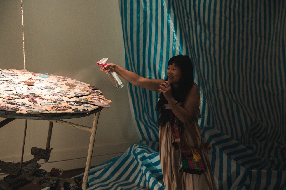 Awa(劉于仙)的作品邀請觀眾噴灑米酒浸潤乾裂的泥巴,並且將鍋子中的泥巴取出再次黏合修補於照片上。(攝影/鄭亦婷)