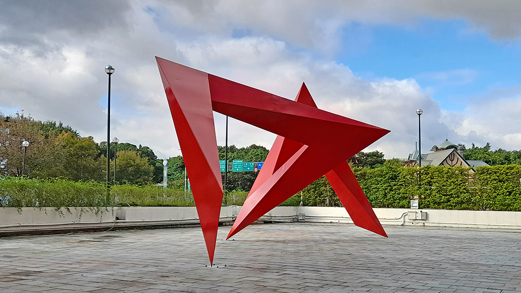 李再鈐，《低限的無限》，鐵板烤漆，500×1000×500 cm，1983。攝於台北市立美術館「狂八〇：跨領域靈光出現的時代」展，2022–2023。