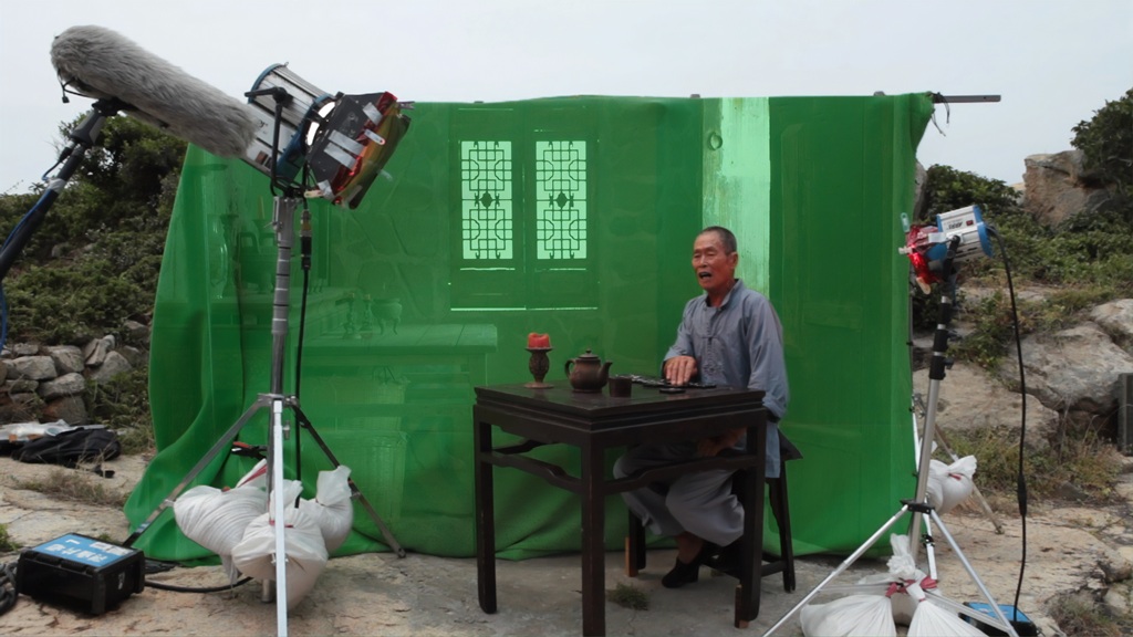 許家維，《鐵甲元帥——龜島》，2012。錄像截圖。畫面之外、舉著左上角收音麥克風桿的，是當年初入行的馮志銘。（許家維工作室提供）
